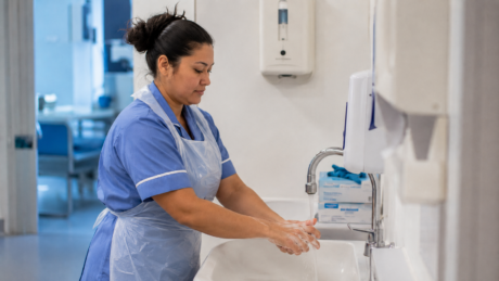 Healthcare Assistant following infection prevention and hand hygiene procedures